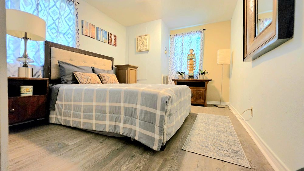 Private suite with upholstered headboard and a small meditation statue