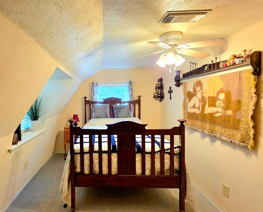 Private suite with an antique bed frame and woven wall tapestry